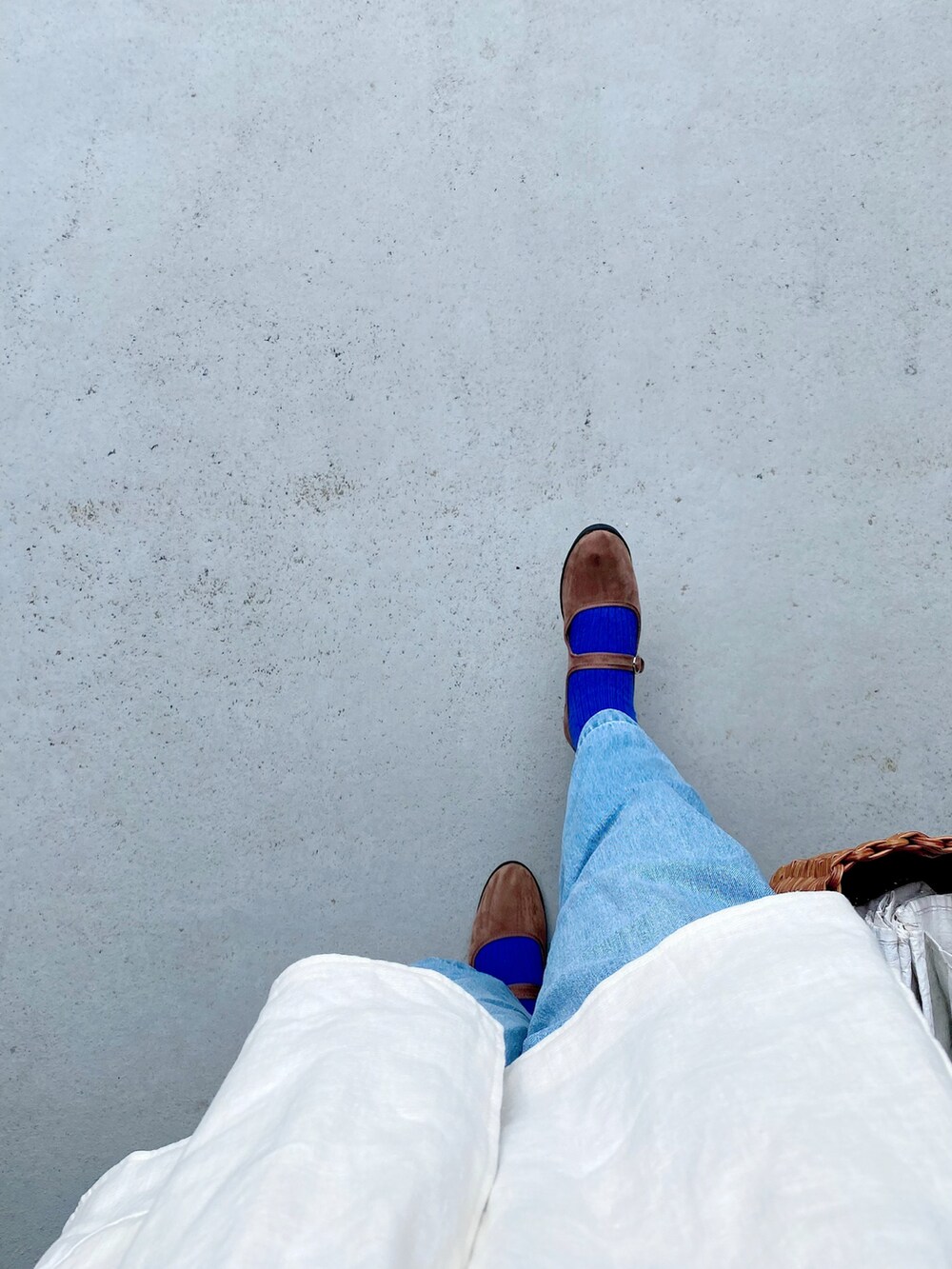 ブラウン系のシューズ、ブルー系のデニムパンツ、ブラウン系のバッグを着用したレディースの春コーディネートの2枚目の写真