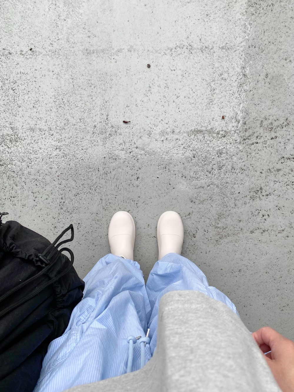 ホワイト系のシューズ、ブルー系のパンツ、ブラック系のバッグを着用したレディースの夏コーディネートの2枚目の写真