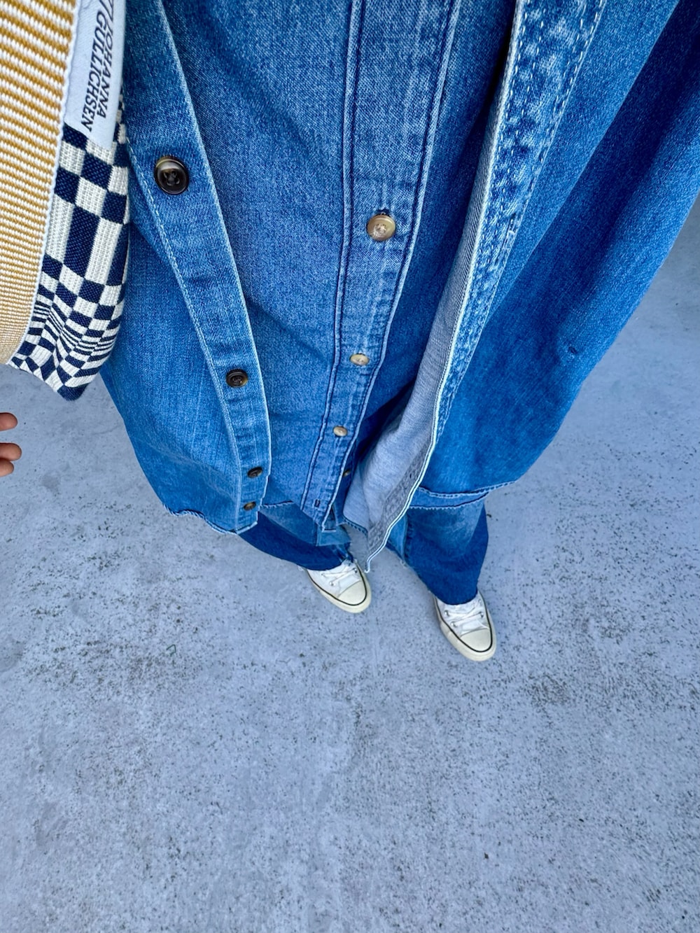 ブルー系のスニーカー、ブルー系のデニムパンツ、ブルー系のワンピースを着用したレディースの冬コーディネートの2枚目の写真