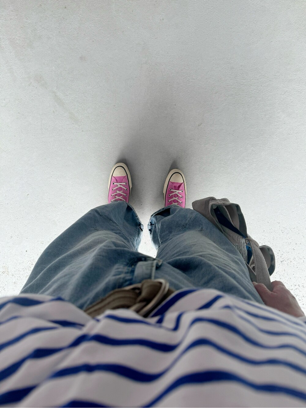 ピンク系のスニーカー、ブルー系のパンツ、グレー系のバッグを着用したレディースの夏コーディネートの2枚目の写真