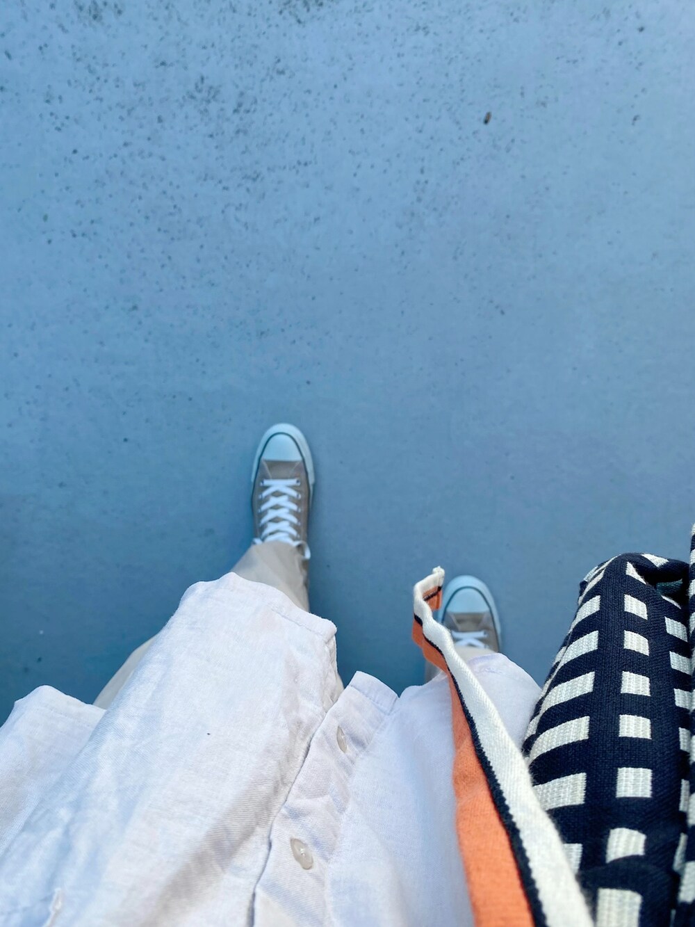 ベージュ系のスニーカー、ベージュ系のパンツ、ブラック系のバッグを着用したレディースの夏コーディネートの2枚目の写真