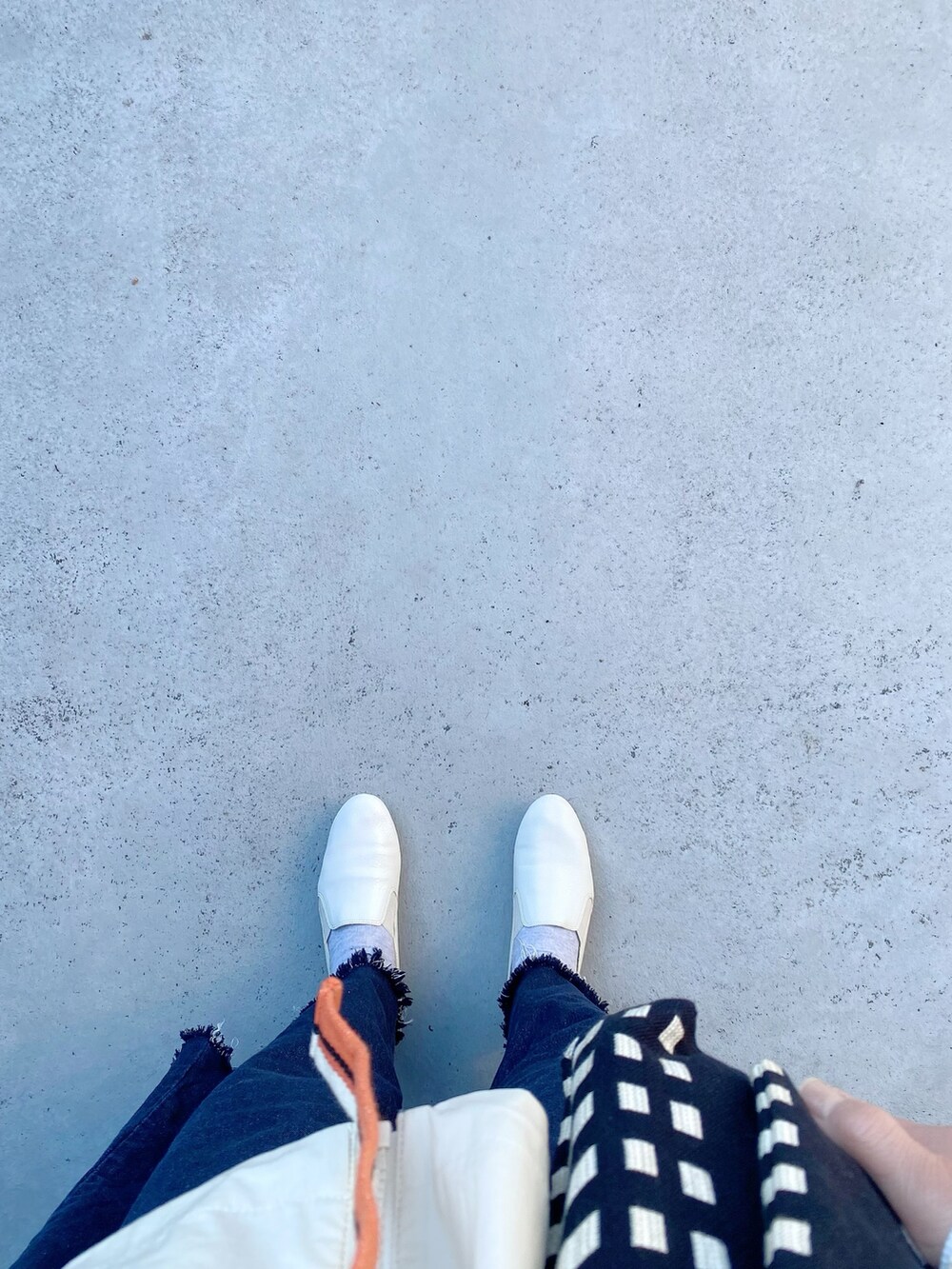 ホワイト系のシューズ、ブルー系のパンツ、ブラック系のバッグを着用したレディースの冬コーディネートの3枚目の写真