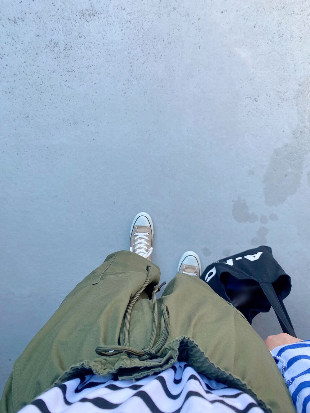 ベージュ系のスニーカー、グリーン系のパンツ、ブラック系のバッグを着用したレディースの秋コーディネートの2枚目の写真