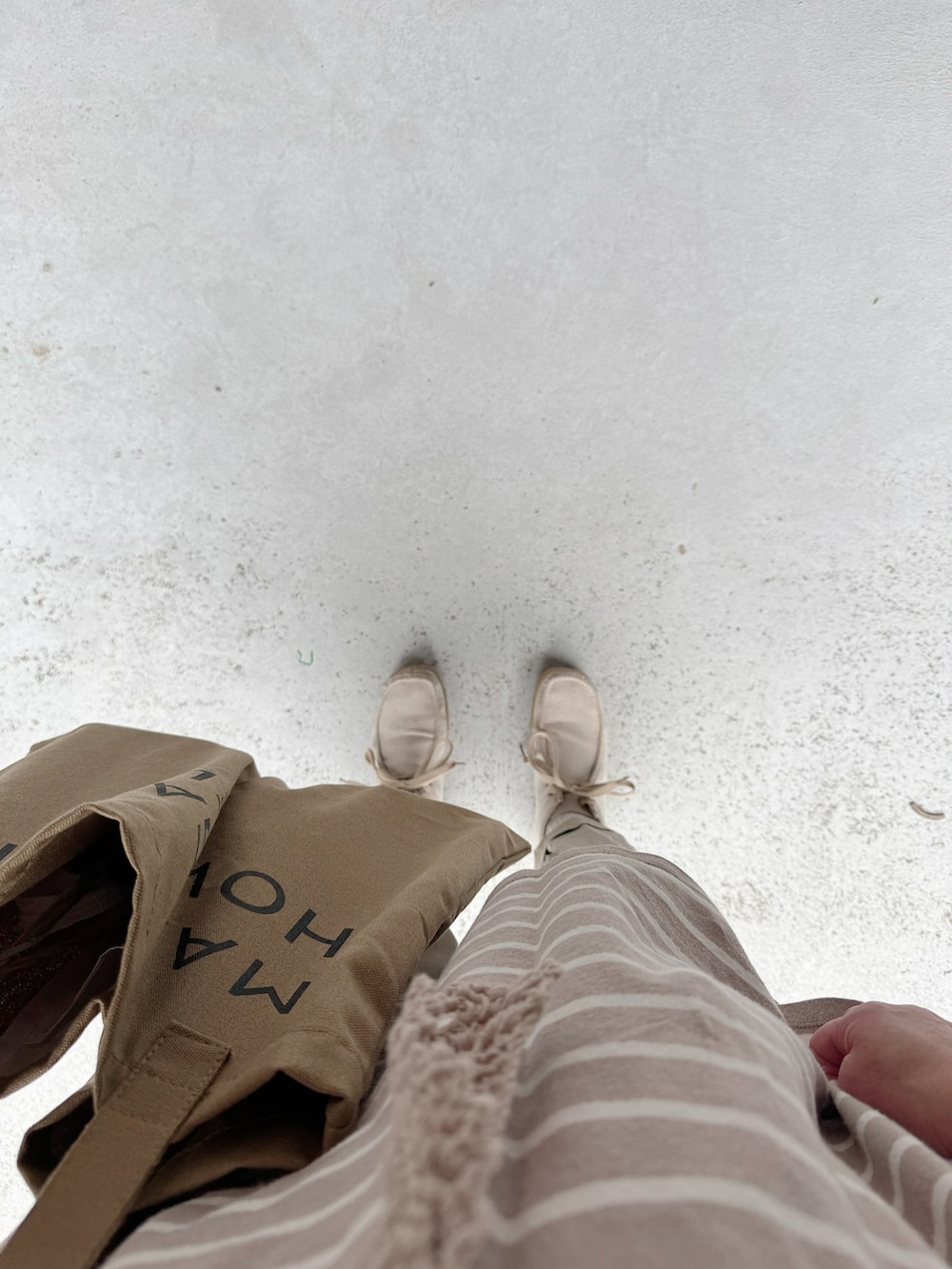 ベージュ系のシューズ、ホワイト系のパンツ、ブルー系のトップスを着用したレディースの春コーディネートの2枚目の写真