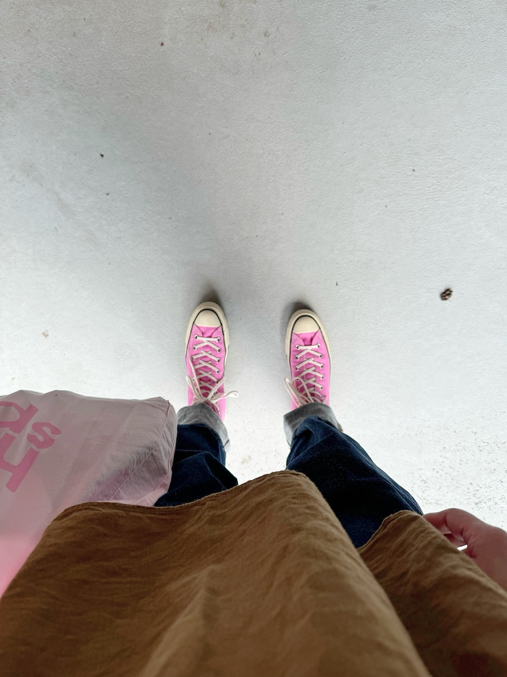 ピンク系のスニーカー、ブルー系のパンツ、ピンク系のバッグを着用したレディースの夏コーディネートの2枚目の写真