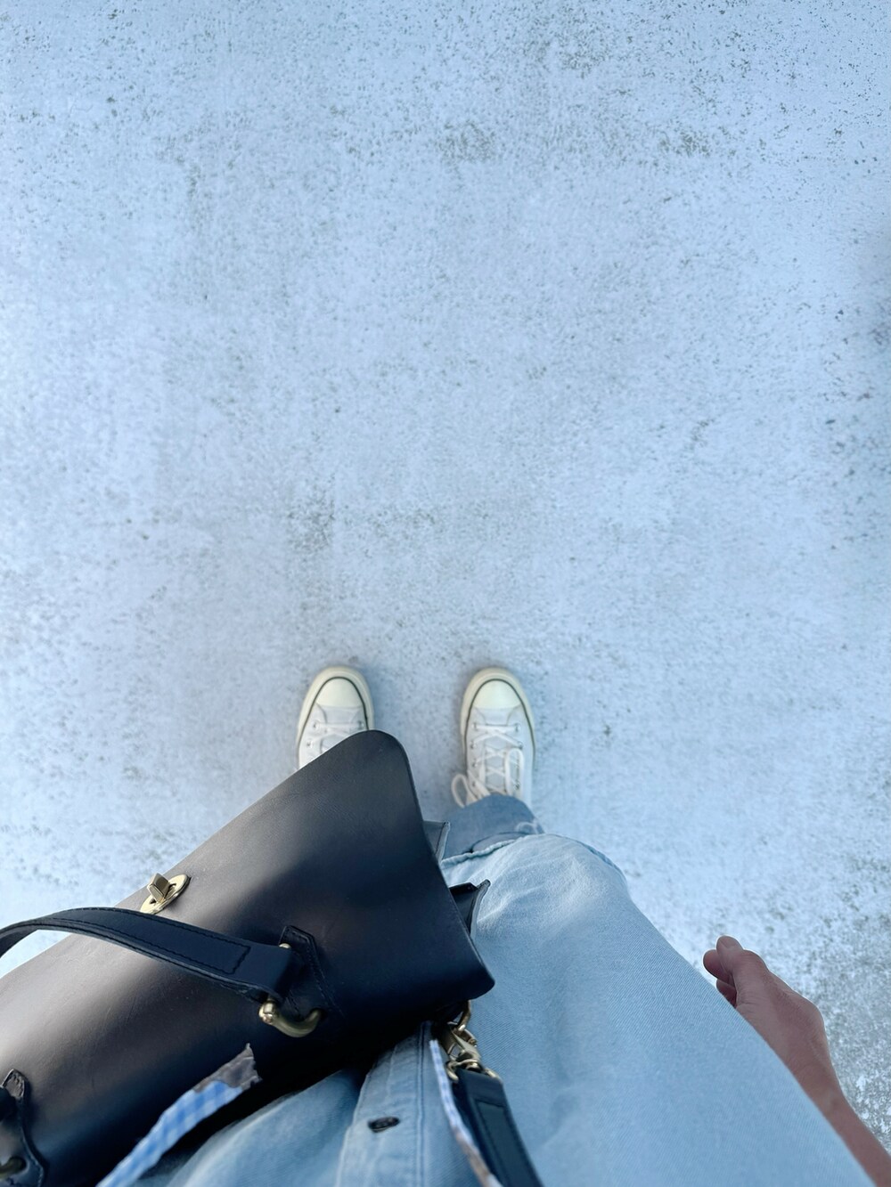 ブルー系のシューズ、ブルー系のデニムパンツ、ブラック系のハンドバッグを着用したレディースの夏コーディネートの2枚目の写真