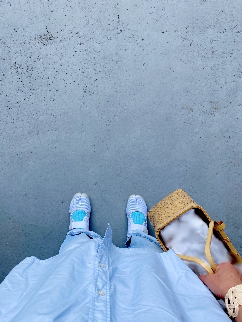 ホワイト系のスニーカー、ブルー系のパンツ、ベージュ系のバッグを着用したレディースの夏コーディネートの2枚目の写真