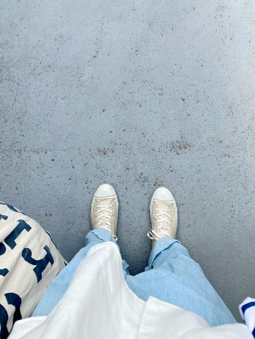 ベージュ系のシューズ、ブルー系のオールインワン・サロペット、ホワイト系のトップスを着用したレディースの春コーディネートの3枚目の写真