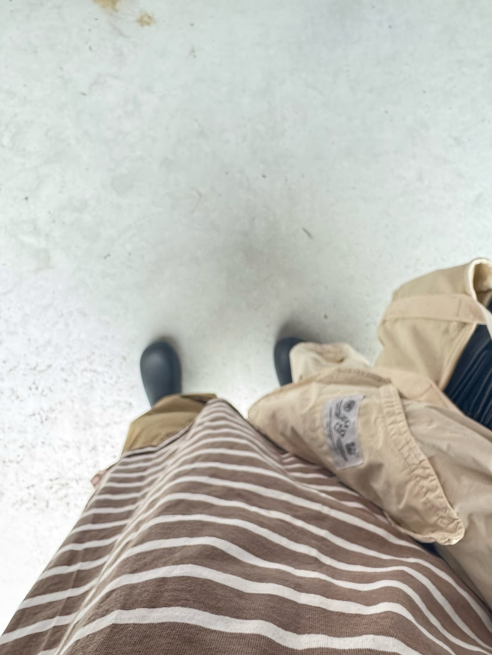 ブラック系のシューズ、ホワイト系のバッグ、ベージュ系のパンツを着用したレディースの春コーディネートの3枚目の写真