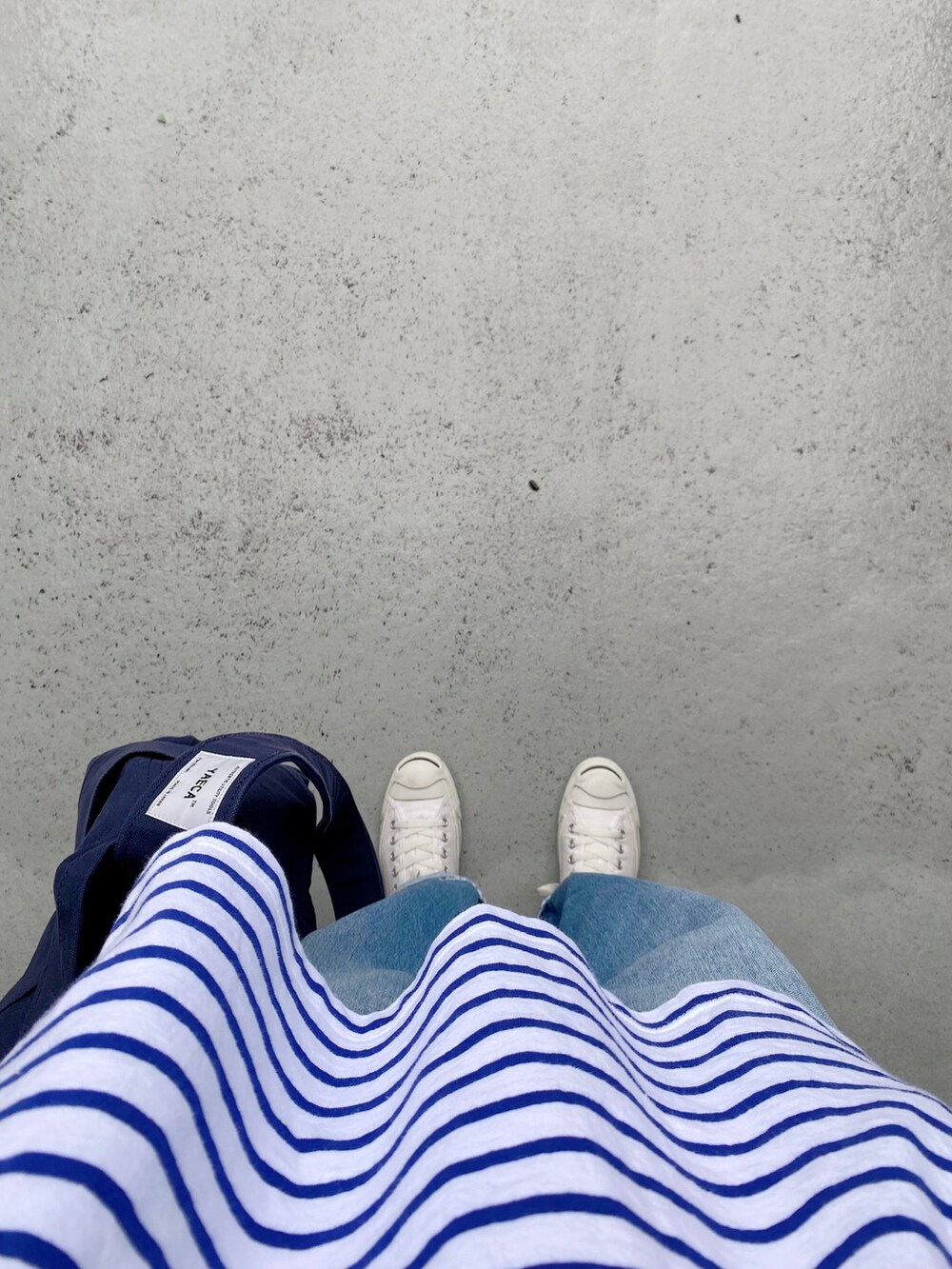 ホワイト系のシューズ、ブルー系のパンツ、ブルー系のバッグを着用したレディースの夏コーディネートの2枚目の写真