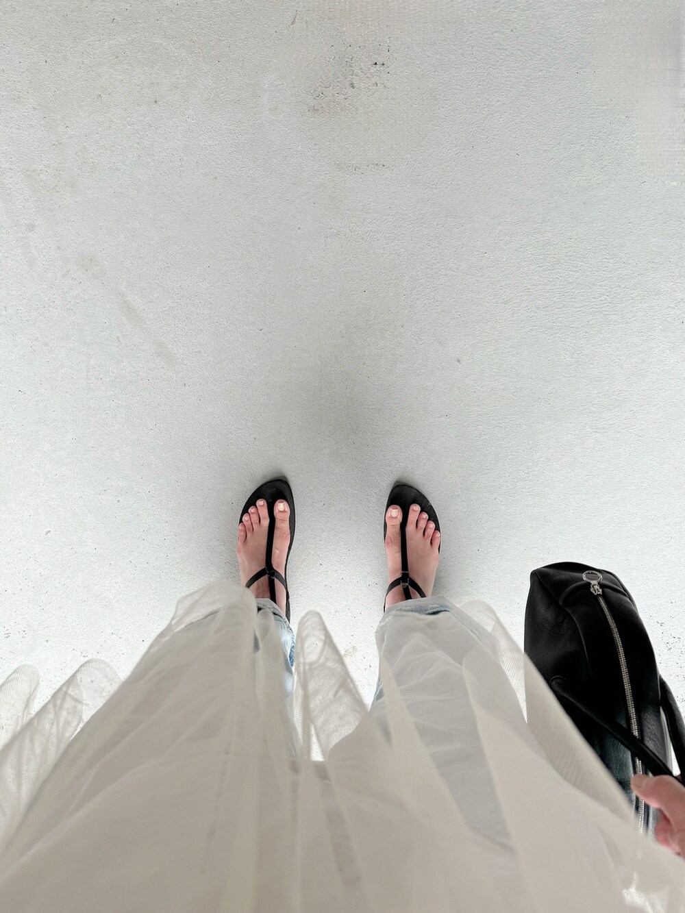 ブラック系のサンダル、ブルー系のパンツ、ブラック系のボストンバッグを着用したレディースの夏コーディネートの3枚目の写真