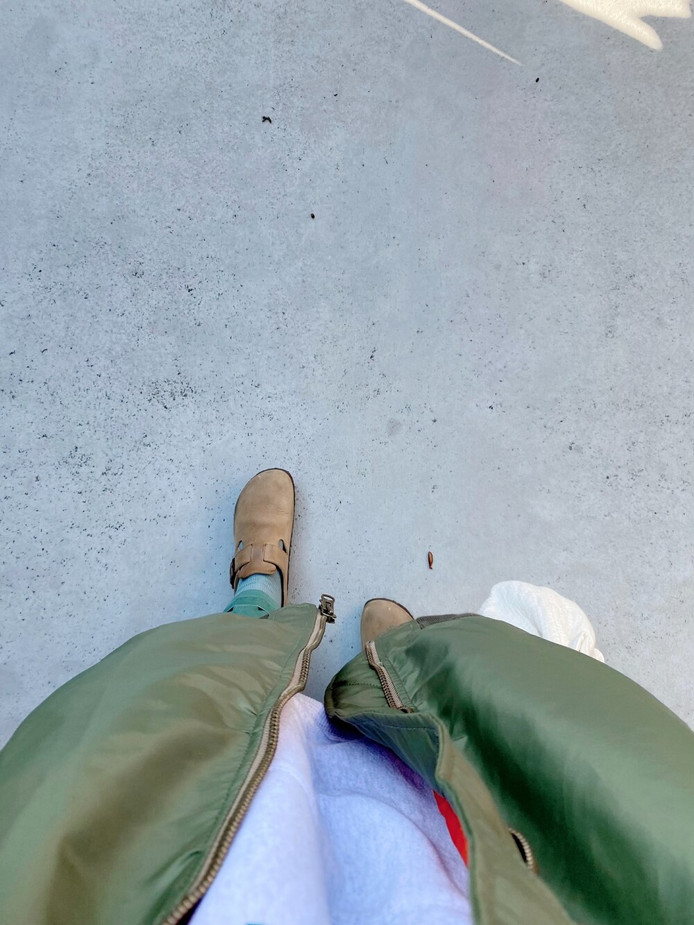 ベージュ系のスリッポン、ホワイト系のパンツ、ホワイト系のバッグを着用したレディースの秋コーディネートの3枚目の写真