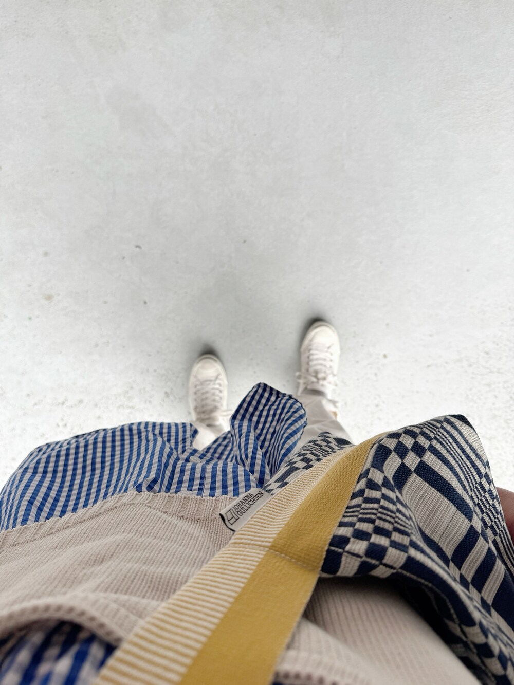 ホワイト系のスニーカー、ホワイト系のパンツ、ブルー系のシャツ/ブラウスを着用したレディースの春コーディネートの2枚目の写真