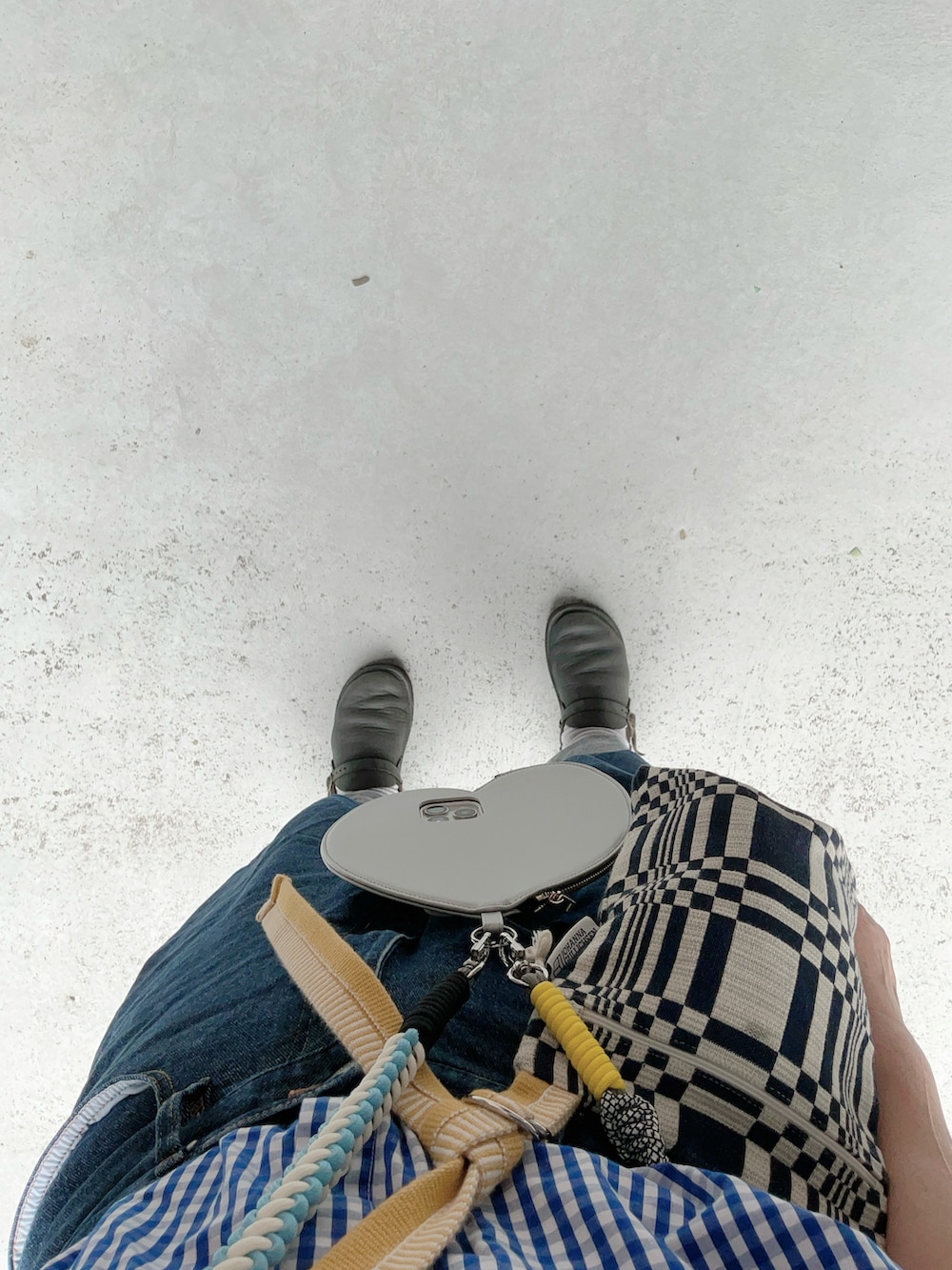 ブラック系のシューズ、ブルー系のパンツ、ブルー系のバッグを着用したレディースの夏コーディネートの2枚目の写真