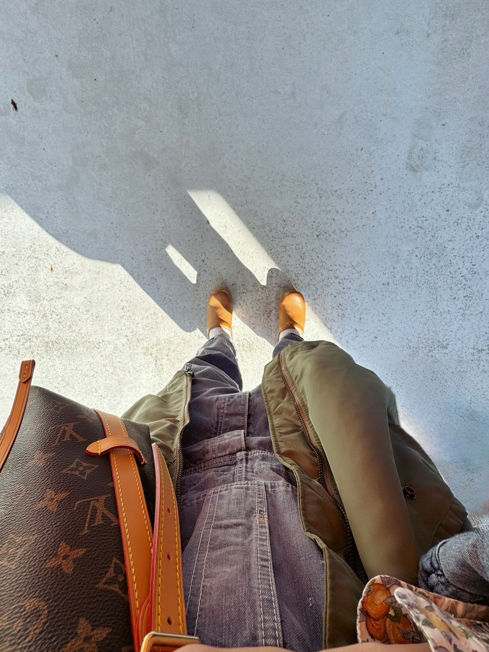 ブラウン系のその他シューズ、ブルー系のオールインワン・サロペット、グリーン系のベストを着用したレディースの秋コーディネートの3枚目の写真