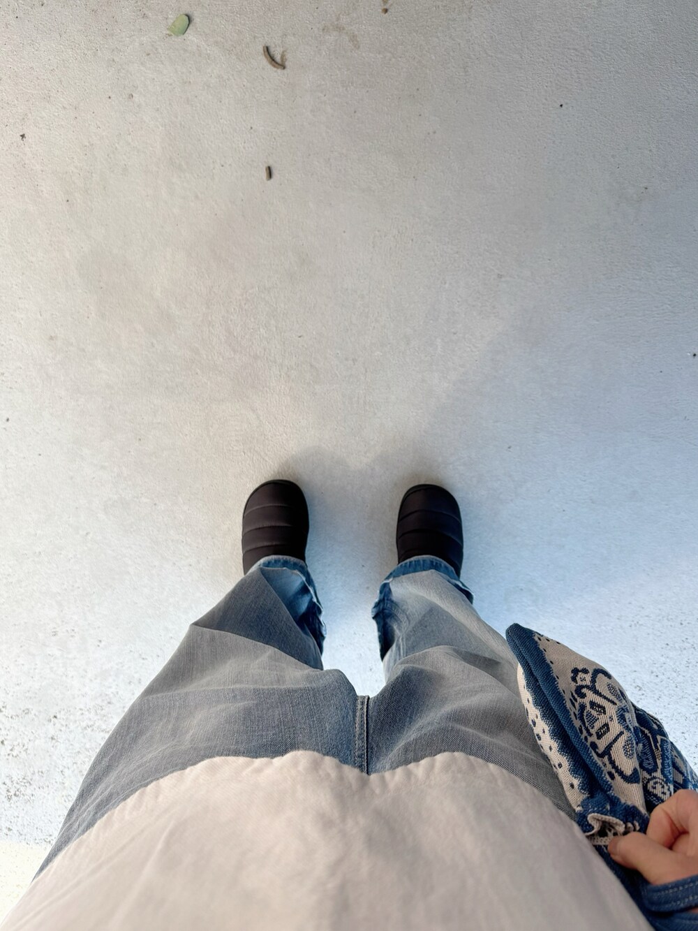 ブラック系のシューズ、ブルー系のデニムパンツ、ブルー系のバッグを着用したレディースの冬コーディネートの2枚目の写真