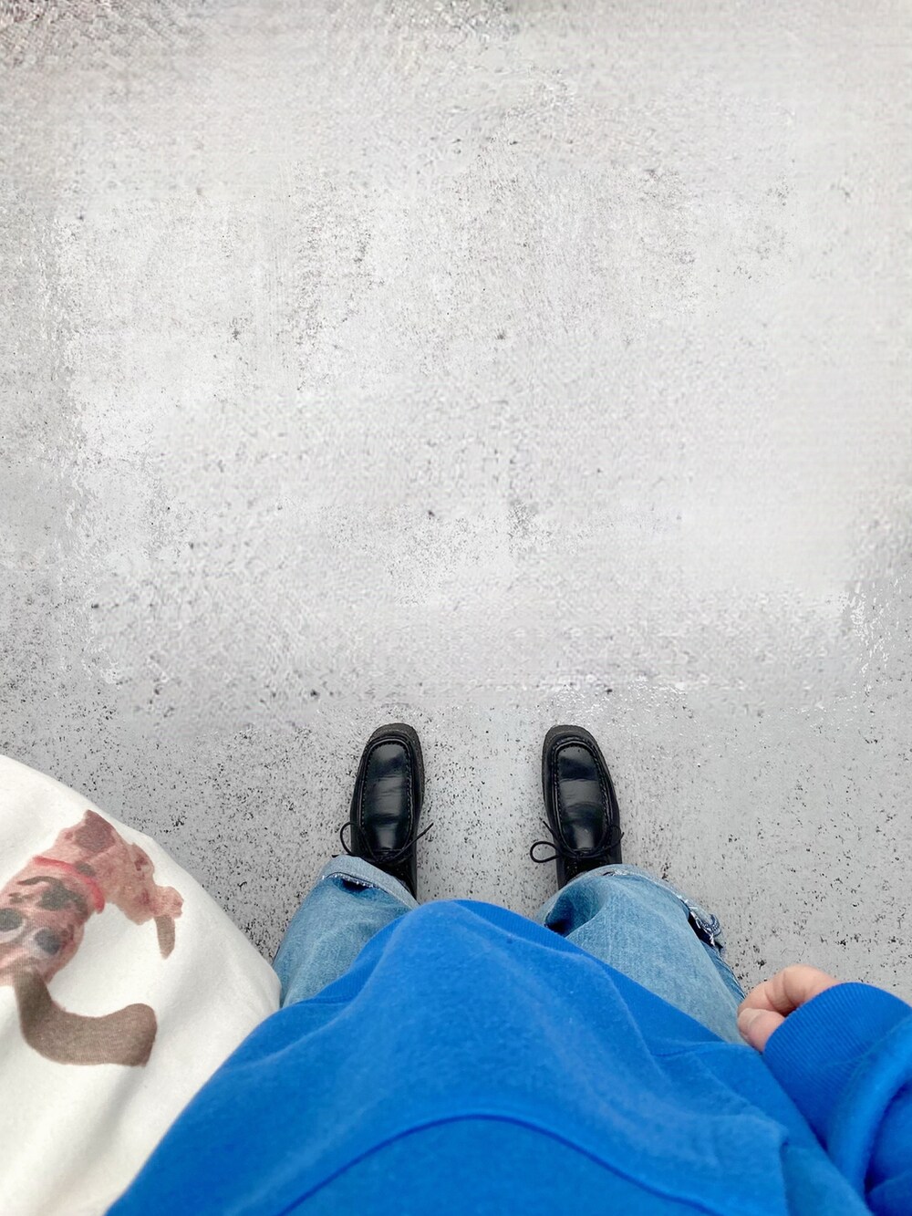 ブラック系のシューズ、ホワイト系のバッグ、ブルー系のパンツを着用したレディースの春コーディネートの2枚目の写真