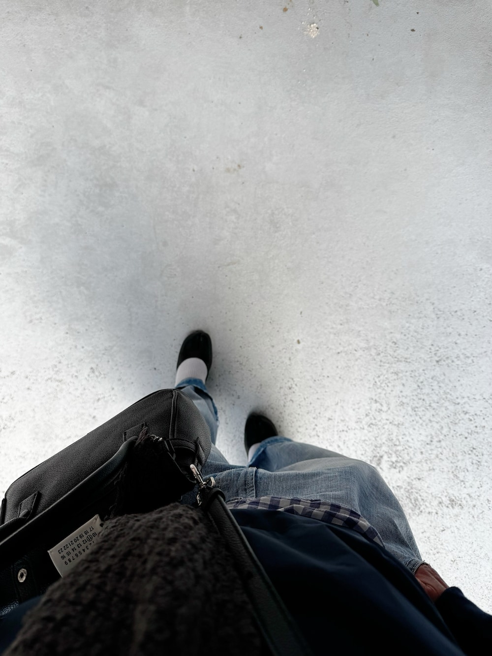 ブラック系のパンプス、ブルー系のデニムパンツ、ブルー系のトップスを着用したレディースの秋コーディネートの2枚目の写真