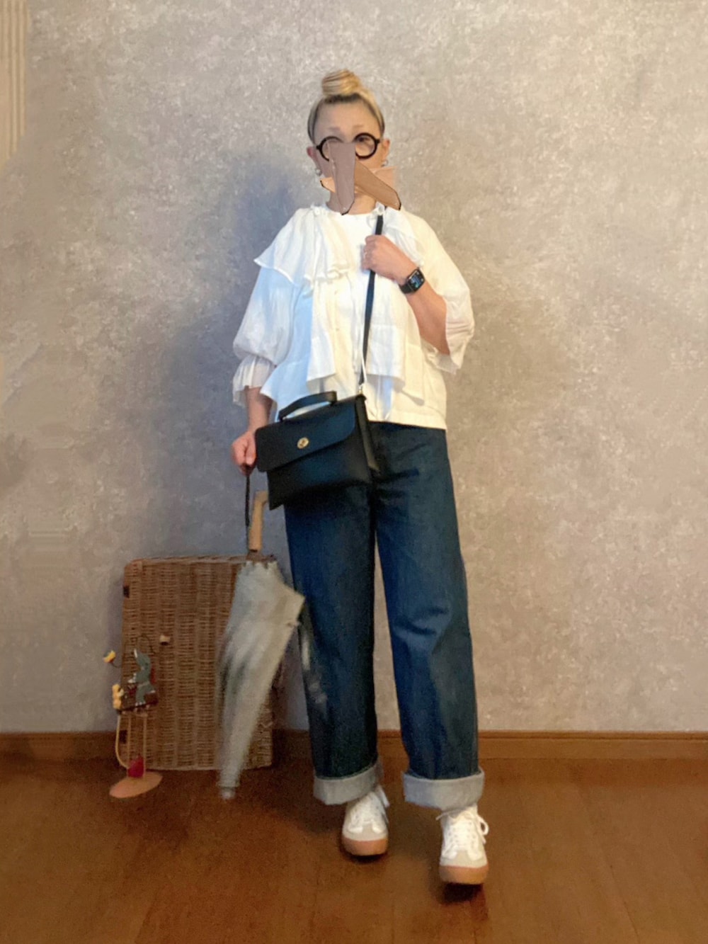 ホワイト系のスニーカー、ブルー系のパンツ、ブラック系のショルダーバッグを着用したレディースの夏コーディネートの2枚目の写真