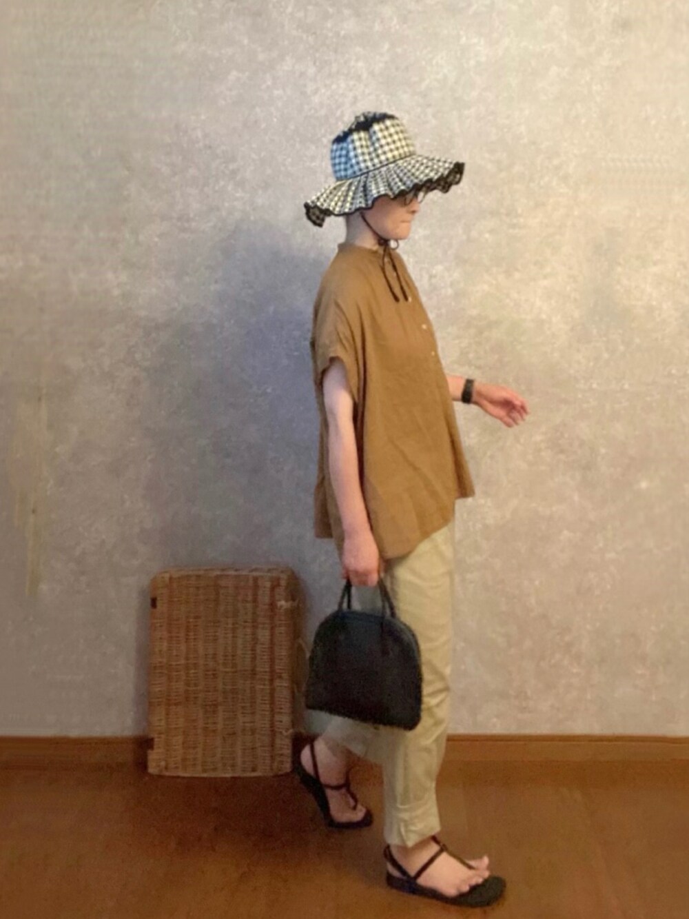 ブラック系のサンダル、ホワイト系のパンツ、ブラック系のボストンバッグを着用したレディースの夏コーディネートの2枚目の写真