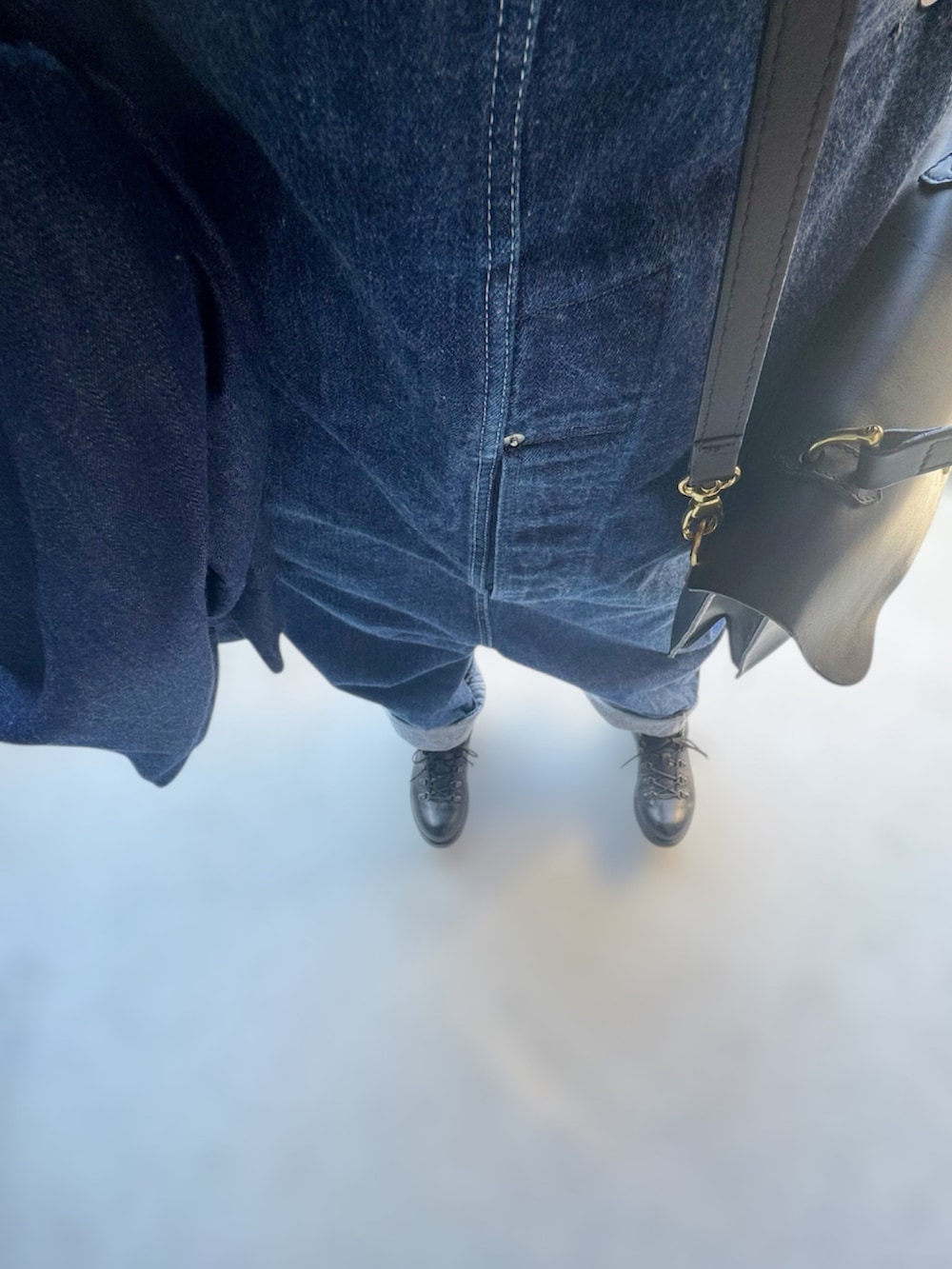 ブラック系のシューズ、ブルー系のオールインワン・サロペット、ブラック系のハンドバッグを着用したレディースの春コーディネートの2枚目の写真