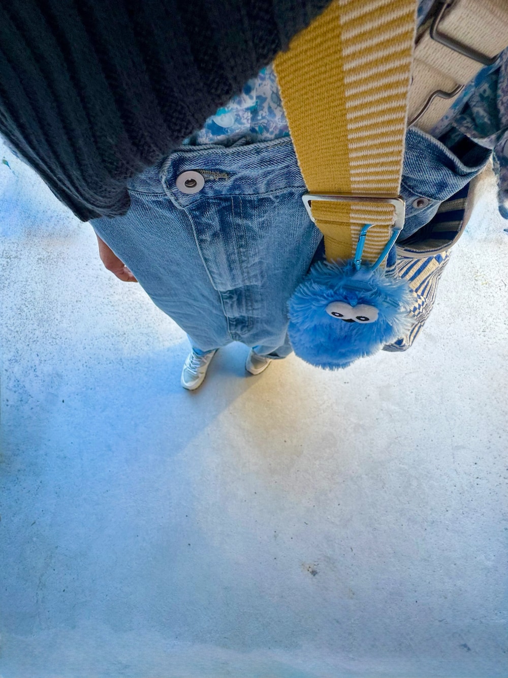 ホワイト系のシューズ、ブルー系のパンツ、ブルー系のバッグを着用したレディースの春コーディネートの3枚目の写真