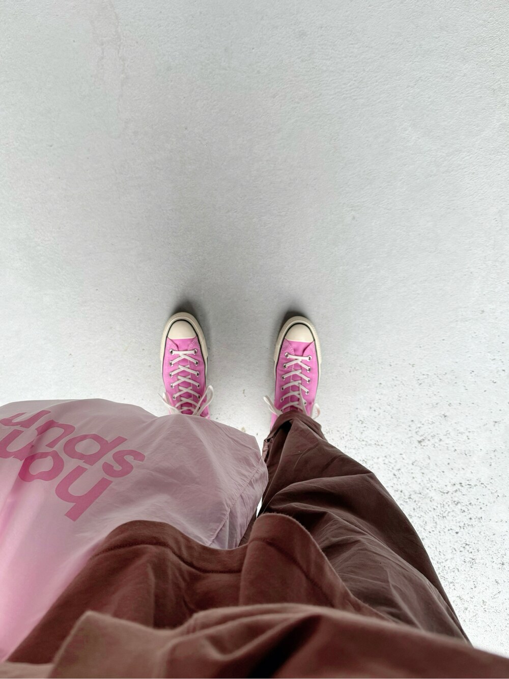 ピンク系のスニーカー、ブラウン系のパンツ、ピンク系のバッグを着用したレディースの春コーディネートの2枚目の写真