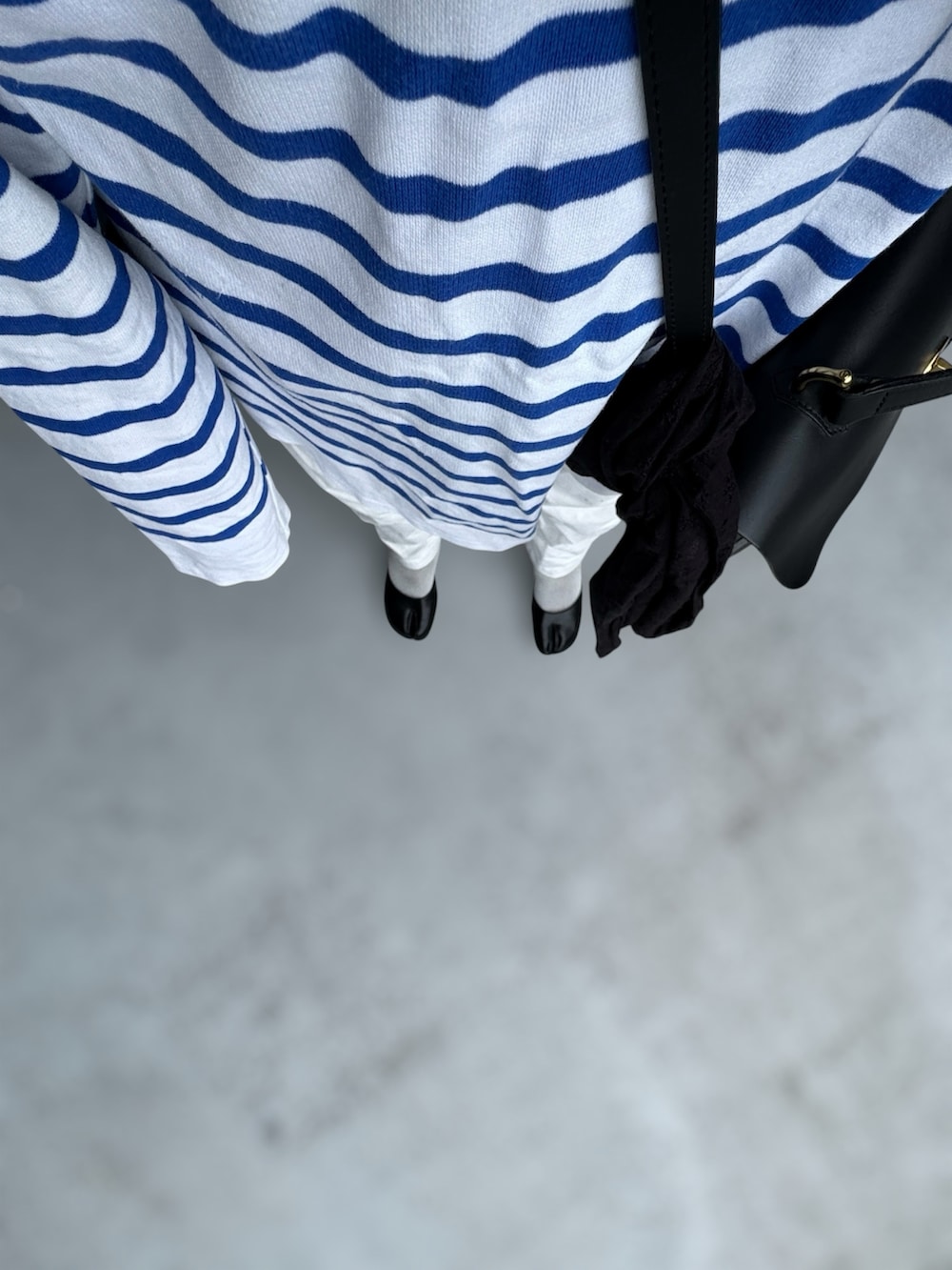 ブラック系のパンプス、ベージュ系のパンツ、ブルー系のトップスを着用したレディースの秋コーディネートの2枚目の写真