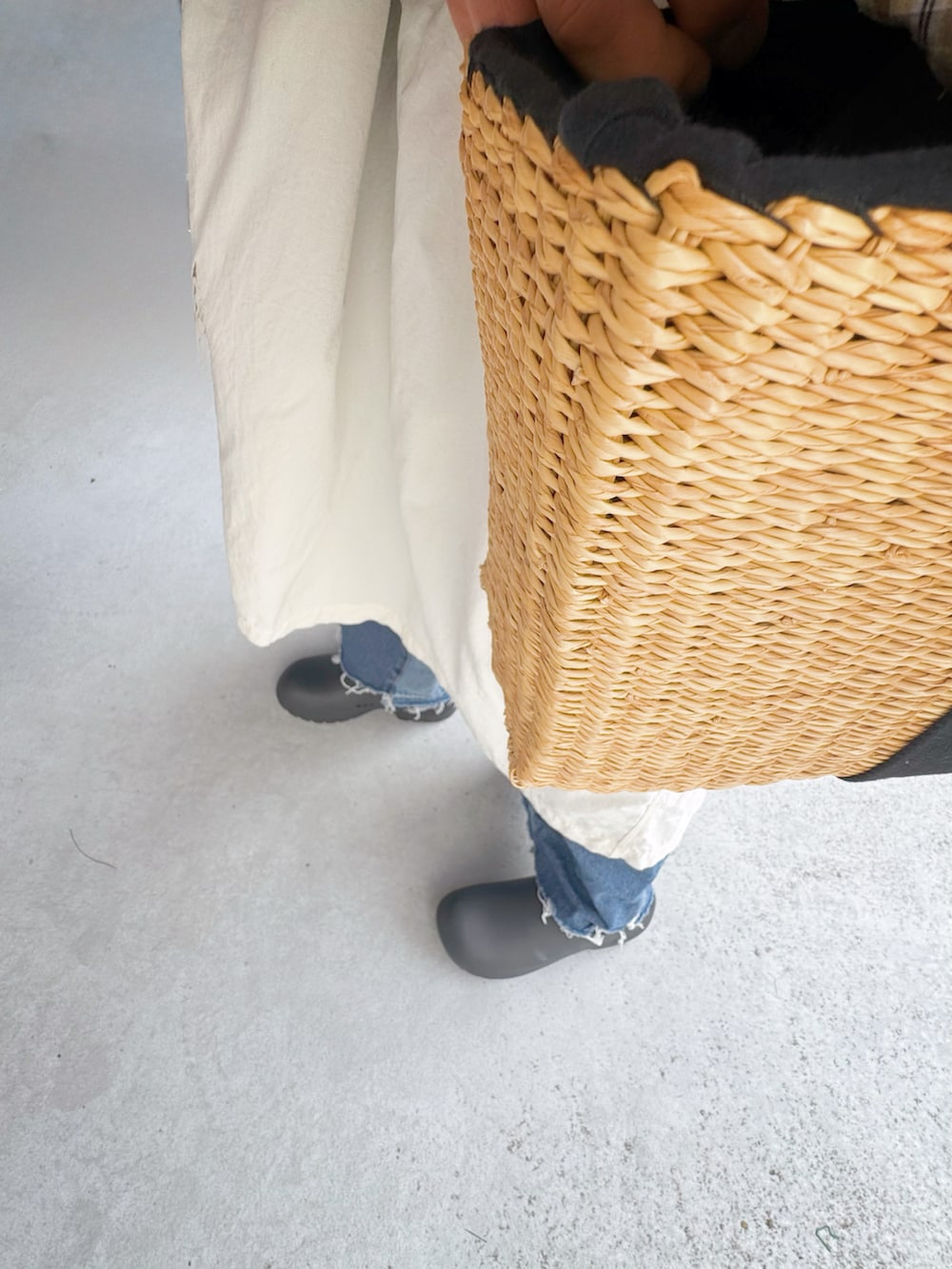 ブラック系のシューズ、ブルー系のデニムパンツ、ホワイト系のポンチョを着用したレディースの冬コーディネートの3枚目の写真