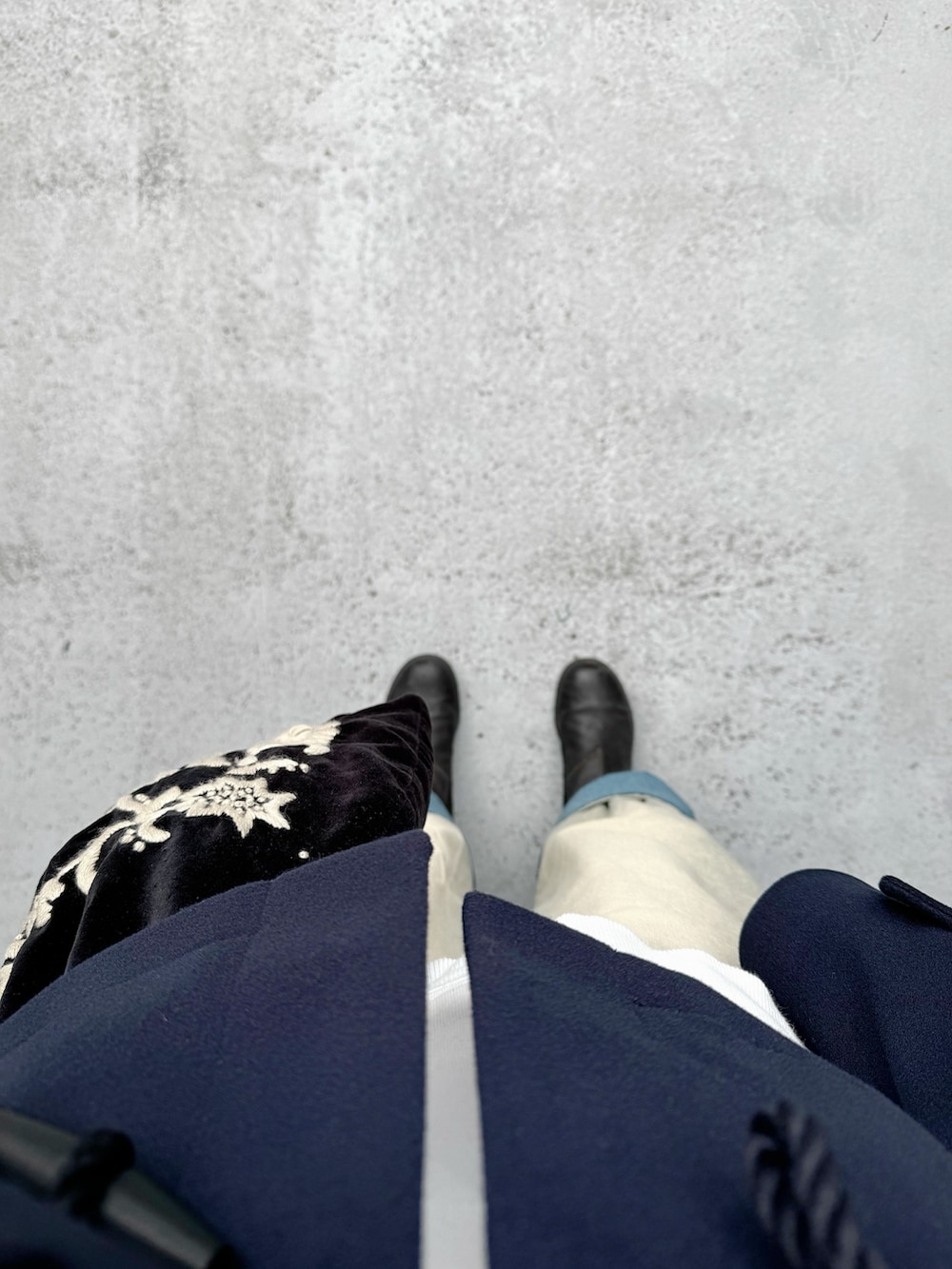 ブラック系のブーツ、ブルー系のパンツ、ブラック系のバッグを着用したレディースの秋コーディネートの3枚目の写真