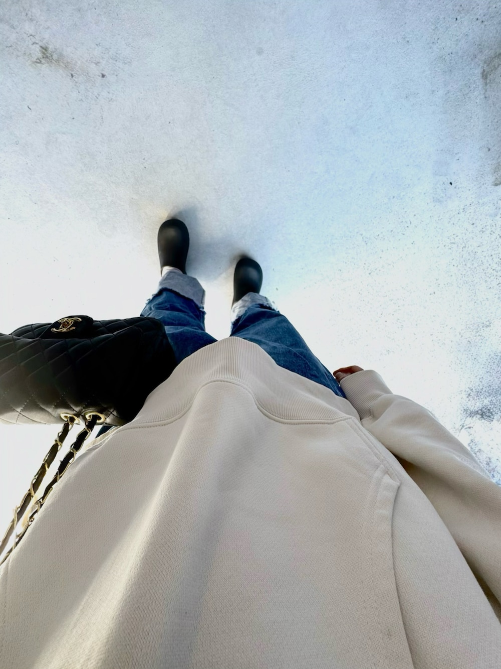 ブラック系のシューズ、ブルー系のデニムパンツ、ホワイト系のトップスを着用したレディースの春コーディネートの2枚目の写真