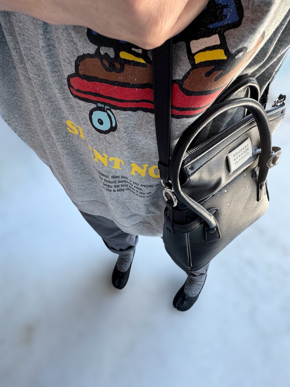 グレー系のパンツ、シルバー系のトップス、ブラック系のトップスを着用したレディースの夏コーディネートの2枚目の写真