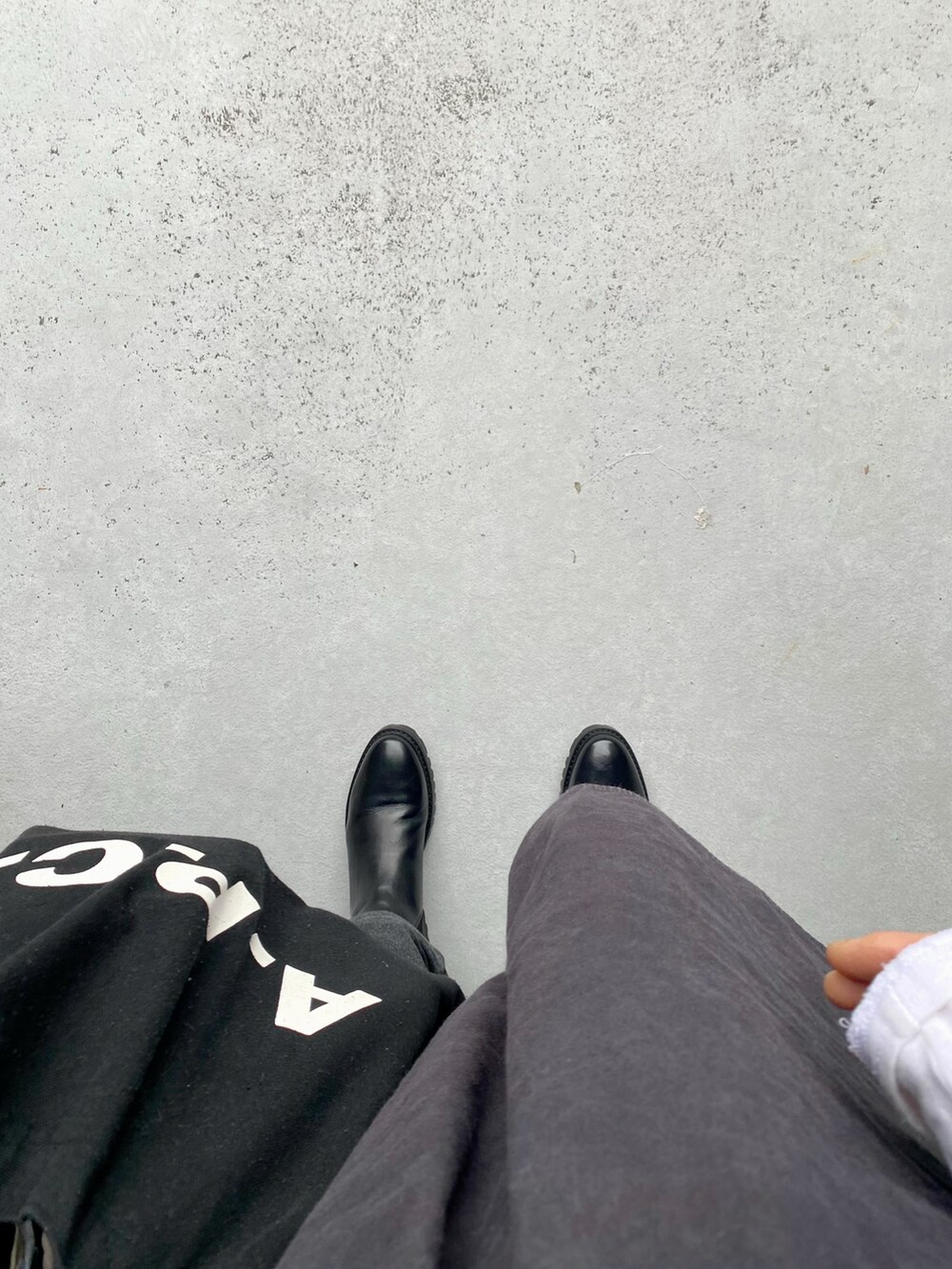 ブラック系のトップス、グレー系のパンツ、ブラック系のトップスを着用したレディースの春コーディネートの2枚目の写真