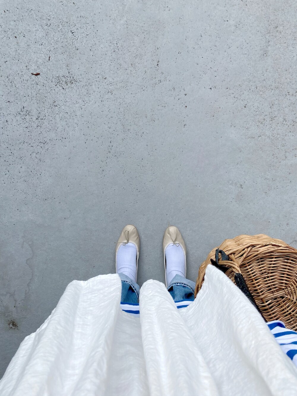 ブルー系のパンツ、ブルー系のトップス、ベージュ系のバッグを着用したレディースの春コーディネートの3枚目の写真