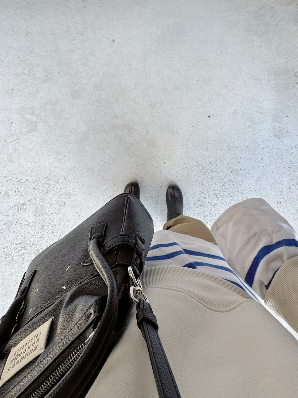 ブラック系のシューズ、ベージュ系のパンツ、ブルー系のトップスを着用したレディースの冬コーディネートの2枚目の写真