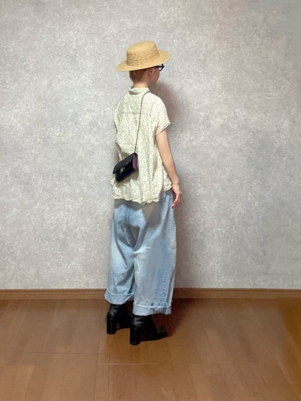 ブラック系のシューズ、ブルー系のデニムパンツ、ベージュ系のトップスを着用したレディースの夏コーディネートの2枚目の写真