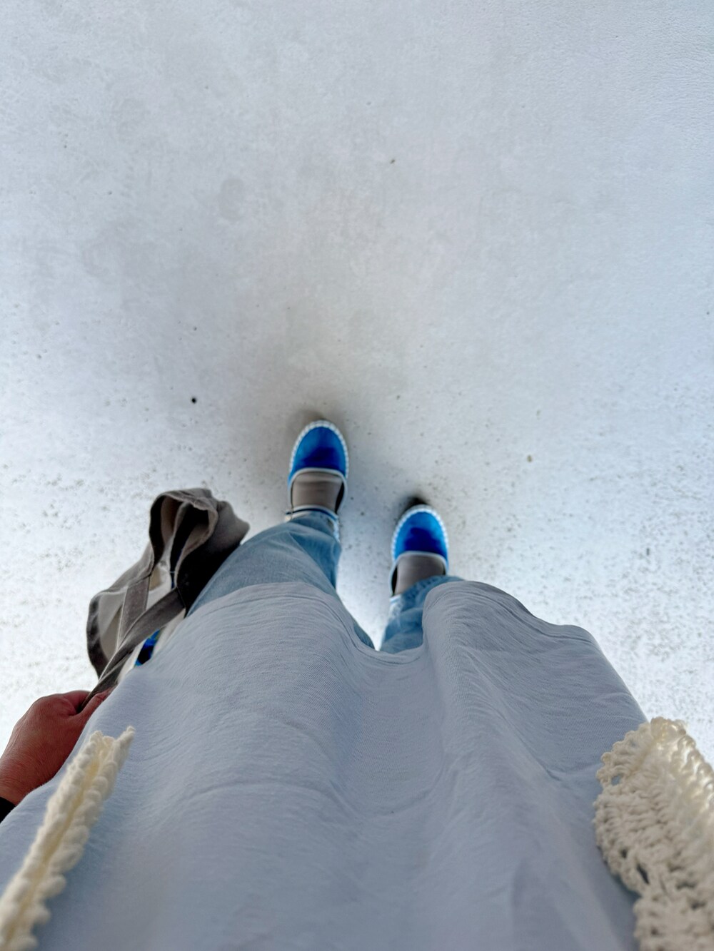 ブルー系のシューズ、ブルー系のデニムパンツ、グレー系のバッグを着用したレディースの秋コーディネートの2枚目の写真