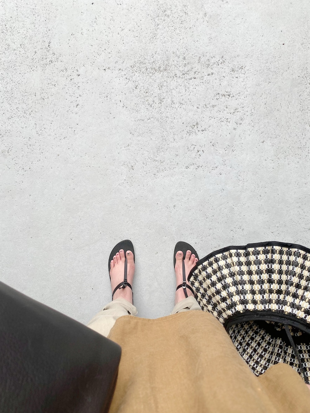 ブラック系のサンダル、ホワイト系のパンツ、ブラック系のボストンバッグを着用したレディースの夏コーディネートの3枚目の写真