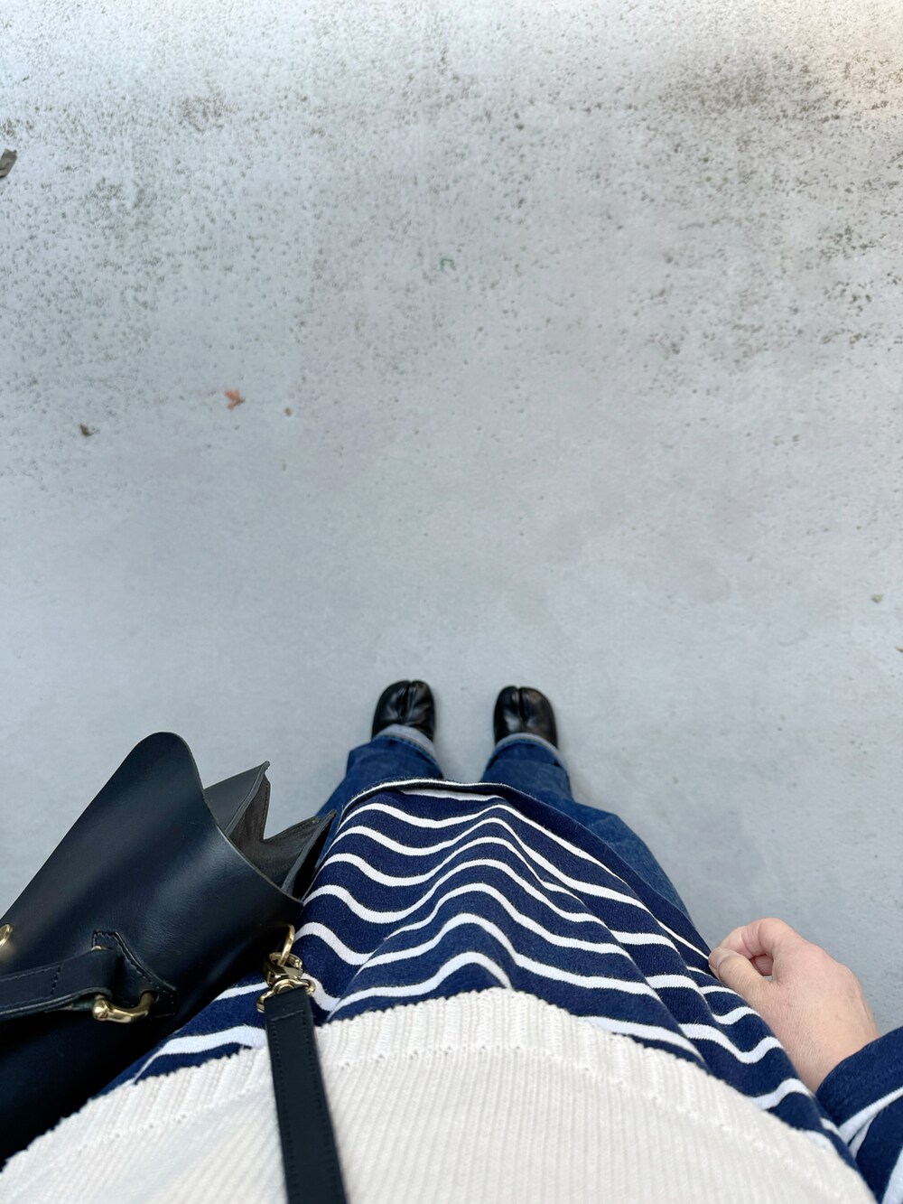 ブラック系のシューズ、ブルー系のデニムパンツ、ブラック系のハンドバッグを着用したレディースの春コーディネートの3枚目の写真