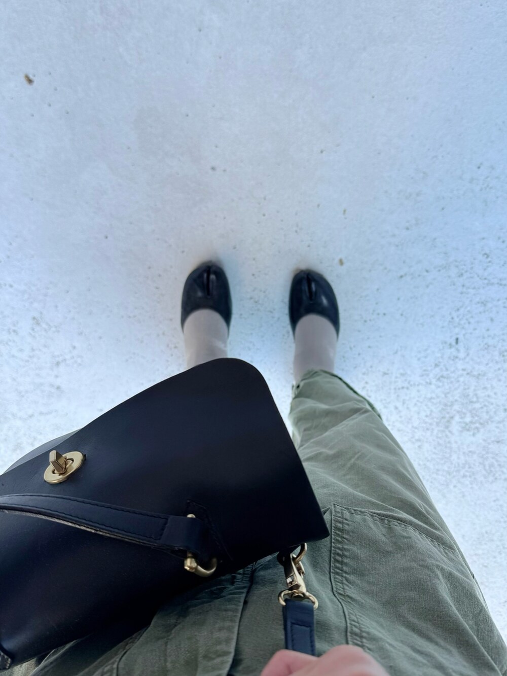 ブラック系のパンプス、グリーン系のパンツ、ブラック系のハンドバッグを着用したレディースの秋コーディネートの2枚目の写真