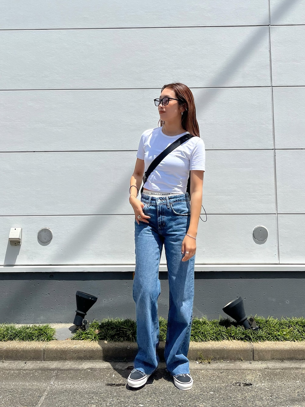 ブラック系のショルダーバッグ、ブラック系のスニーカー、ブラック系のサングラスを着用したレディースの春コーディネートの2枚目の写真