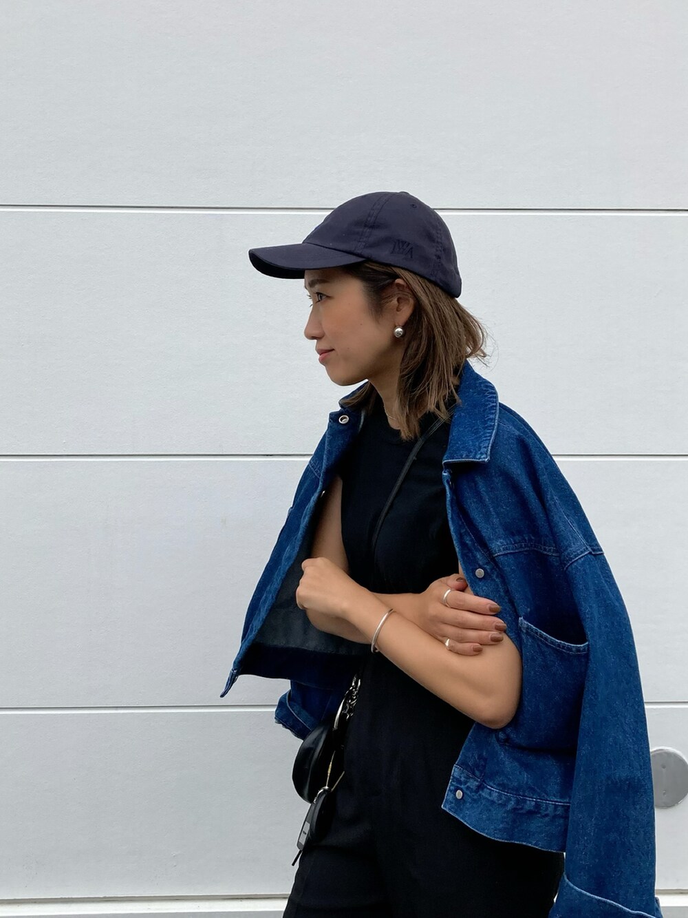 ブラック系のその他パンツ、ブラック系のドラムバッグ、ブラック系のスニーカーを着用したレディースの春コーディネートの2枚目の写真