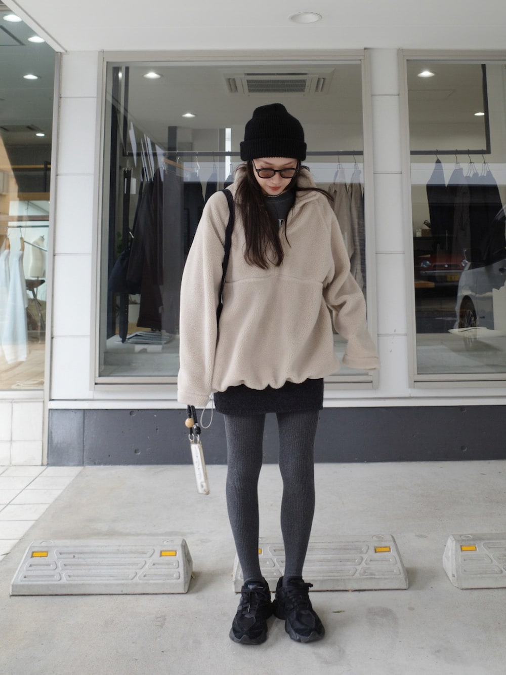 グレー系のスカート、ブラック系のスニーカー、グレー系のタイツ/ストッキングを着用したレディースの冬コーディネートの2枚目の写真