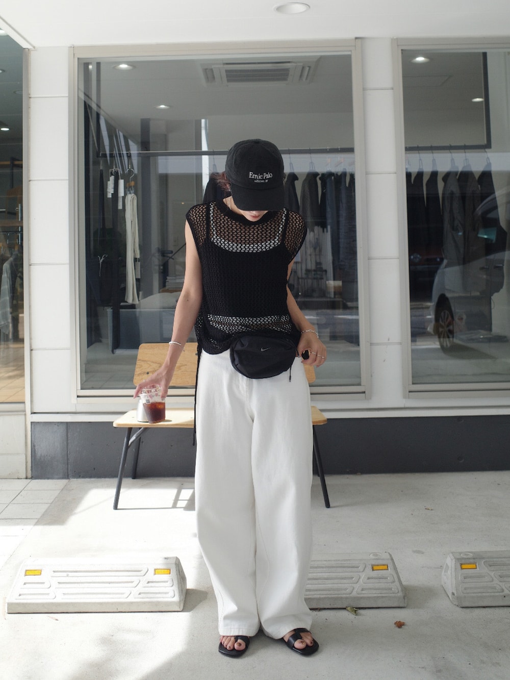 ブラック系のタンクトップ、ブラック系のボディバッグ/ウエストポーチ、ブラック系のサンダルを着用したレディースの夏コーディネートの2枚目の写真