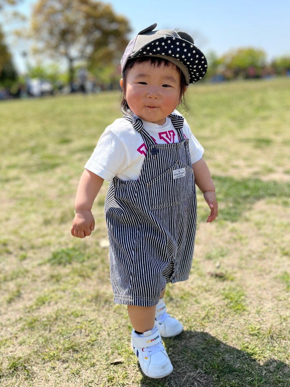 ブルー系のサロペット/オーバーオール、ホワイト系のTシャツ/カットソー、ホワイト系のスニーカーを着用したレディースの春コーディネートの2枚目の写真