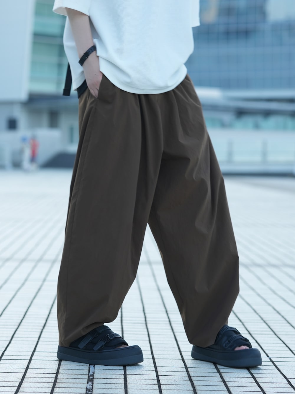 ホワイト系のTシャツ/カットソー、ブラック系のタンクトップ、ブラウン系のその他パンツを着用したメンズの夏コーディネートの4枚目の写真