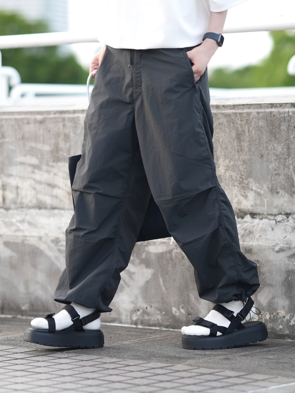 ホワイト系のTシャツ/カットソー、グレー系のカーゴパンツ、ブラック系のサンダルを着用したメンズの夏コーディネートの4枚目の写真