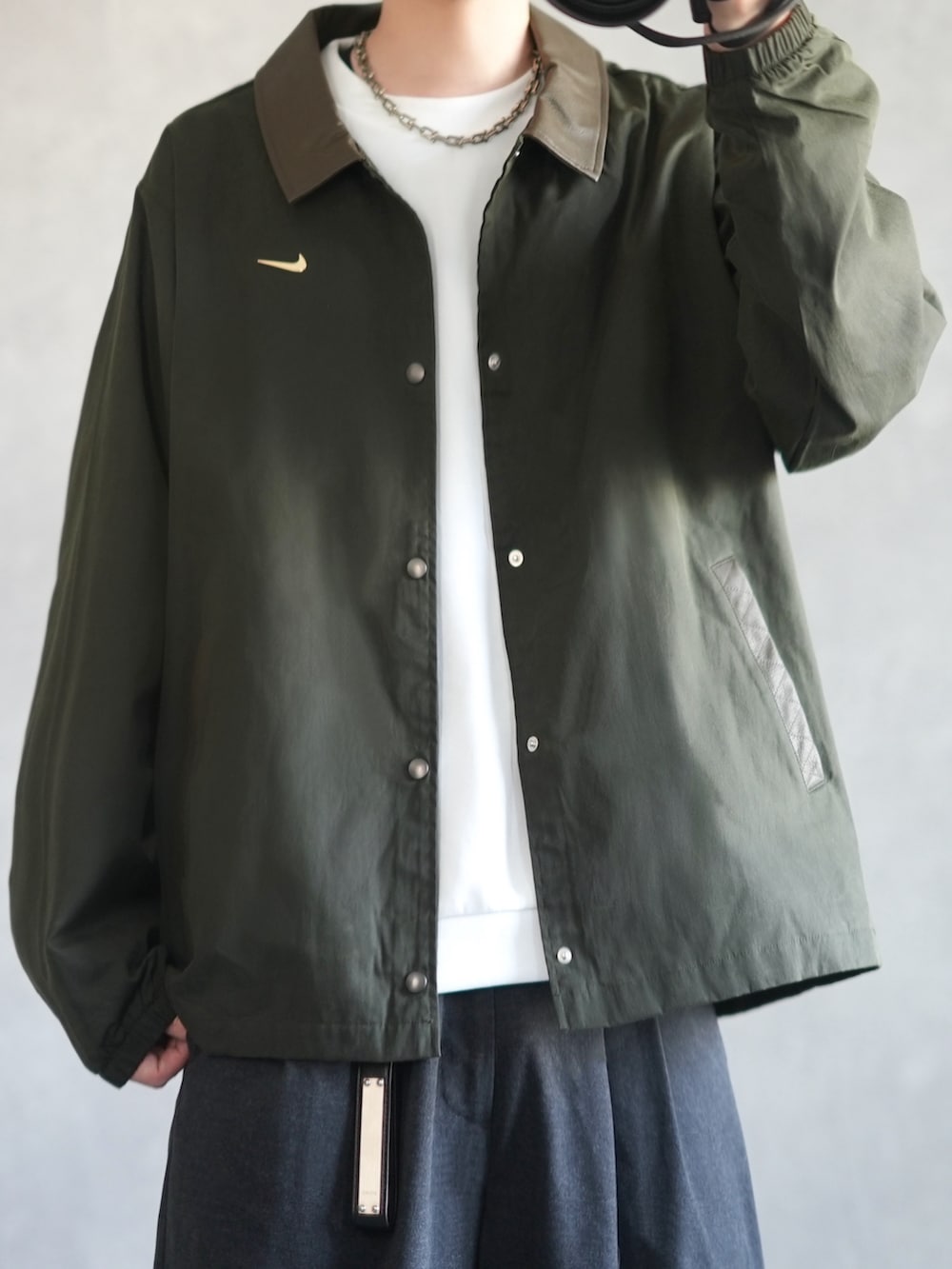 グリーン系のその他アウター、ホワイト系のスウェット、グレー系のスラックスを着用したメンズの冬コーディネートの2枚目の写真