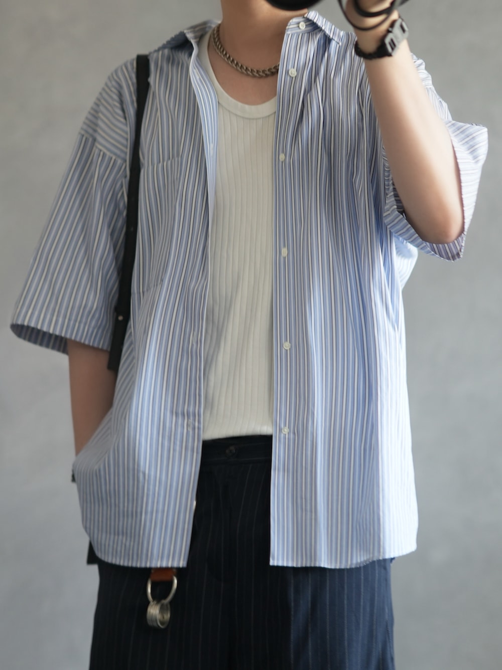 ブルー系のシャツ/ブラウス、ブルー系のスラックス、ブラック系のローファーを着用したメンズの夏コーディネートの2枚目の写真