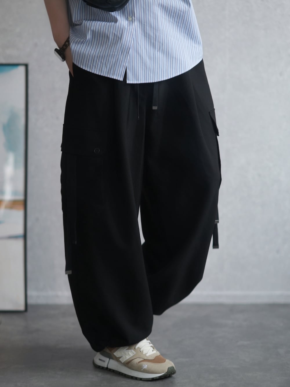 ブルー系のシャツ/ブラウス、ブラック系のカーゴパンツ、ベージュ系のスニーカーを着用したメンズの夏コーディネートの3枚目の写真